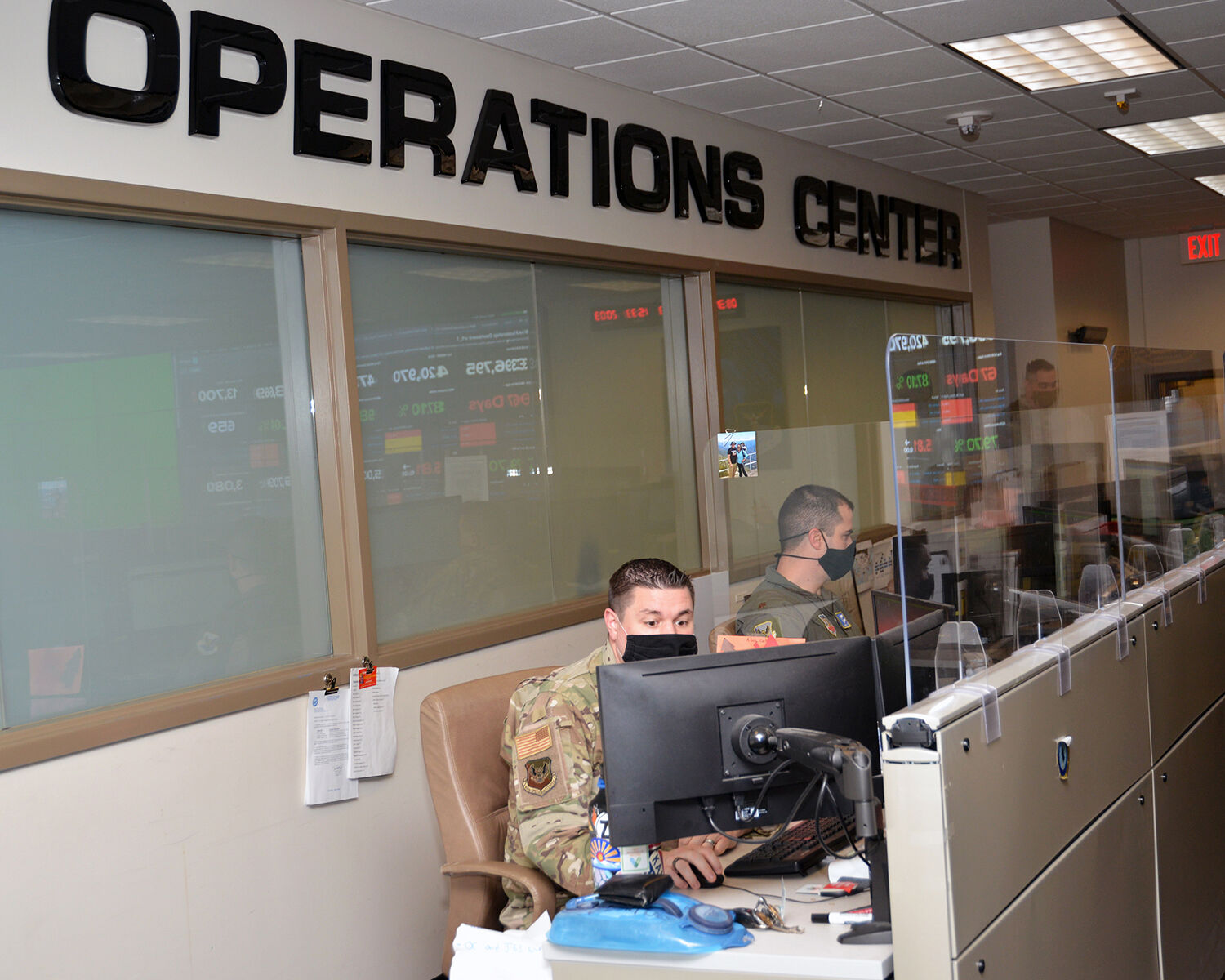 Operations centre personnel monitoring enterprise network defence dashboards